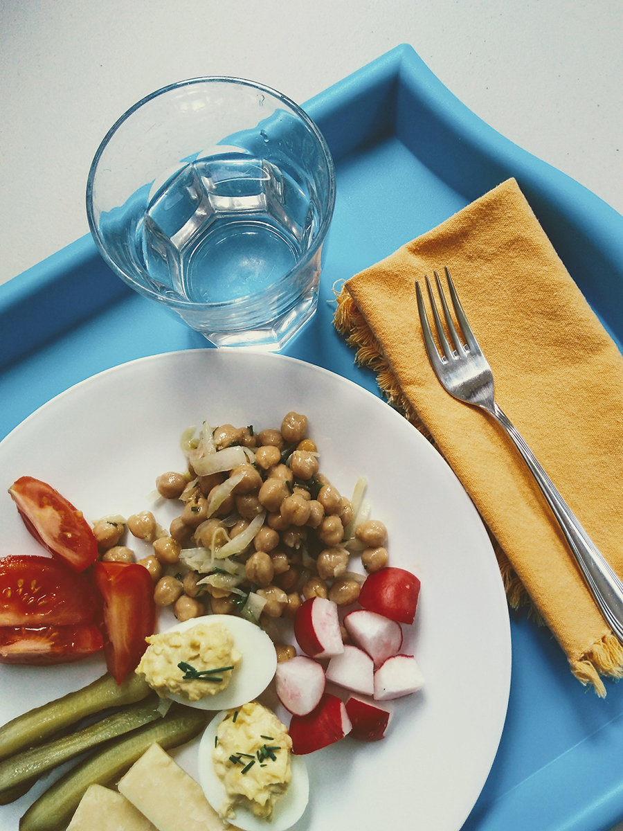 An aspirational school lunch on a tray with cutlery and glassware and linens and a well-balanced meal